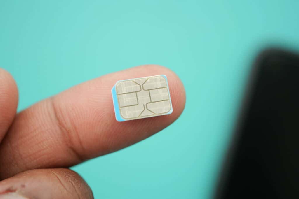 close up of sim card on finger on blue 2026 09 24 15 49 10 utc