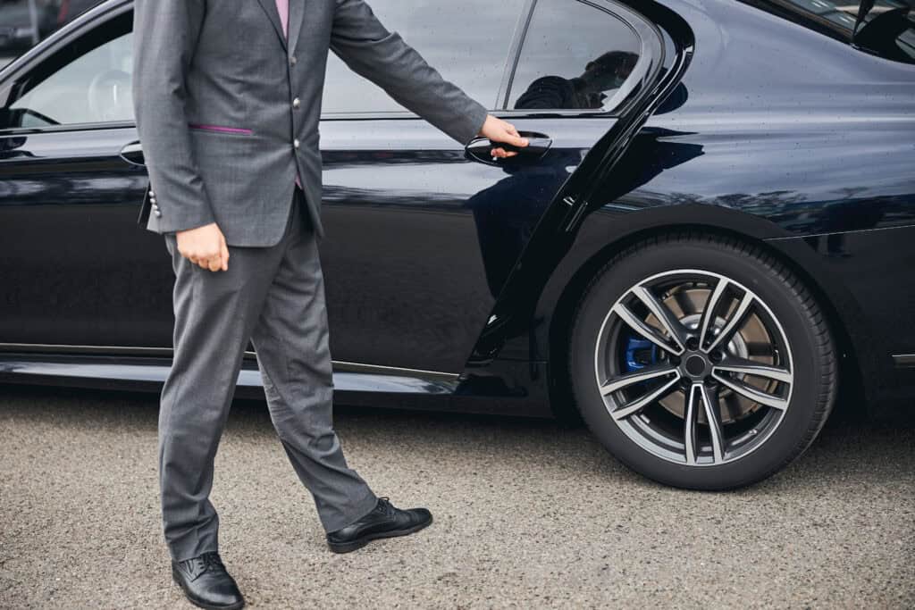 man in suit opens car door on street 2026 09 22 00 26 08 utc