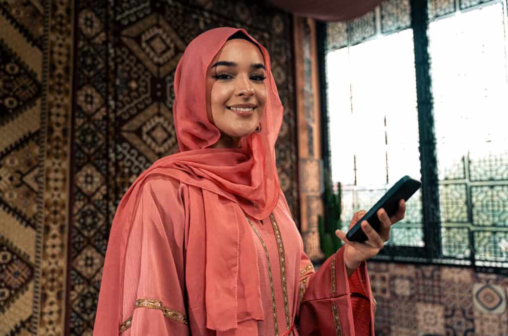smiling woman holding phone indoors near a window 2026 09 24 06 04 06 utc