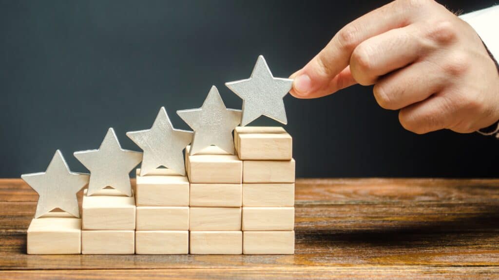 hand places star rating symbol on wooden blocks 2026 09 22 02 54 32 utc