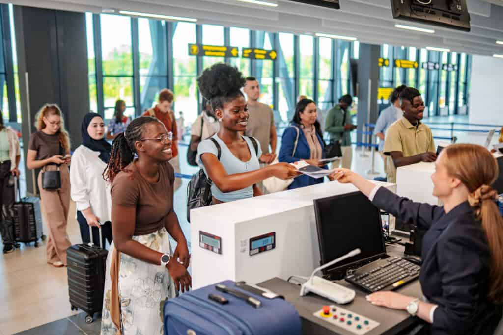young woman handing passport to airline agent at a 2026 09 25 07 19 49 utc